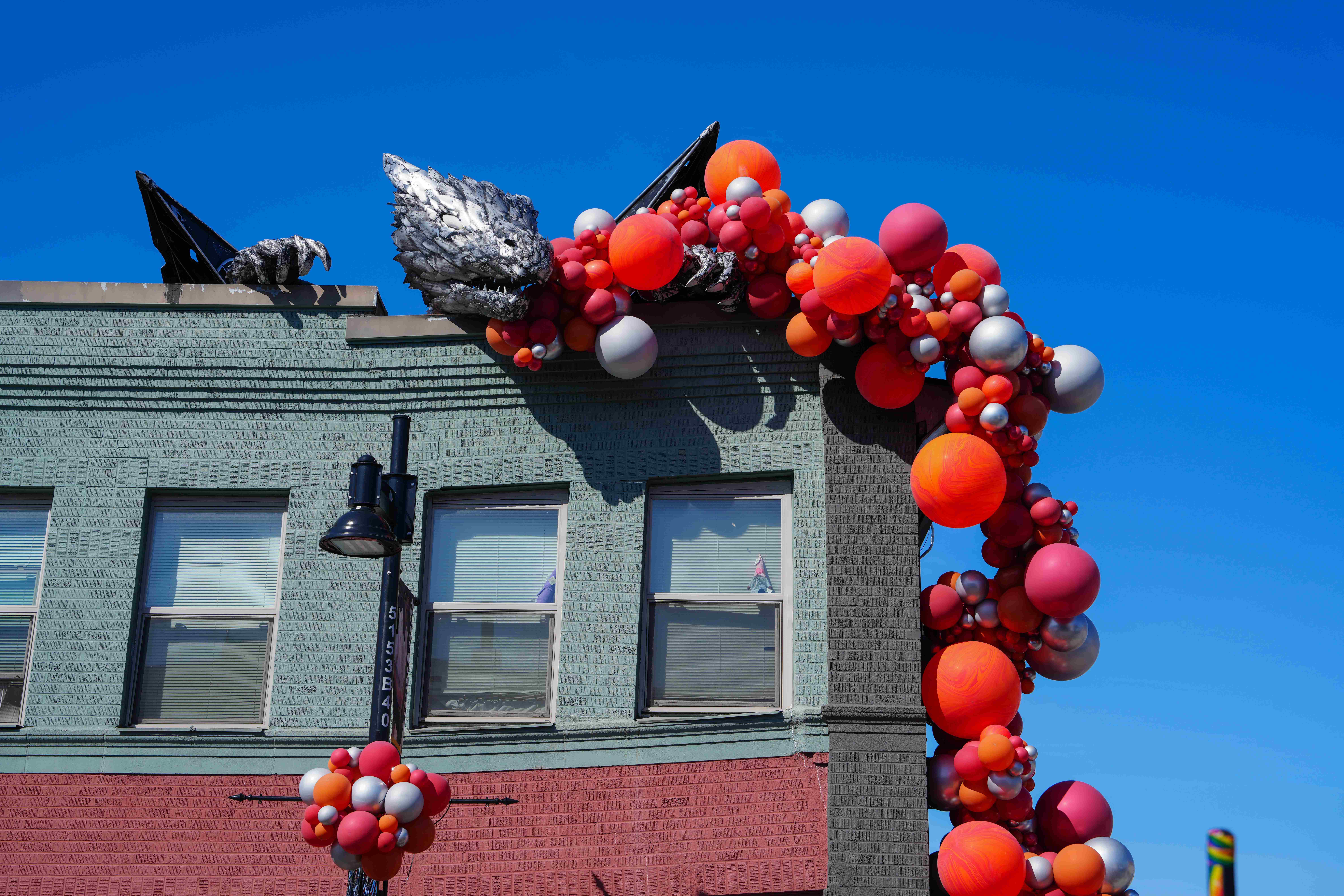 2025 Dragons Landing Celebration with image of Erasmus Renton's rooftop dragon