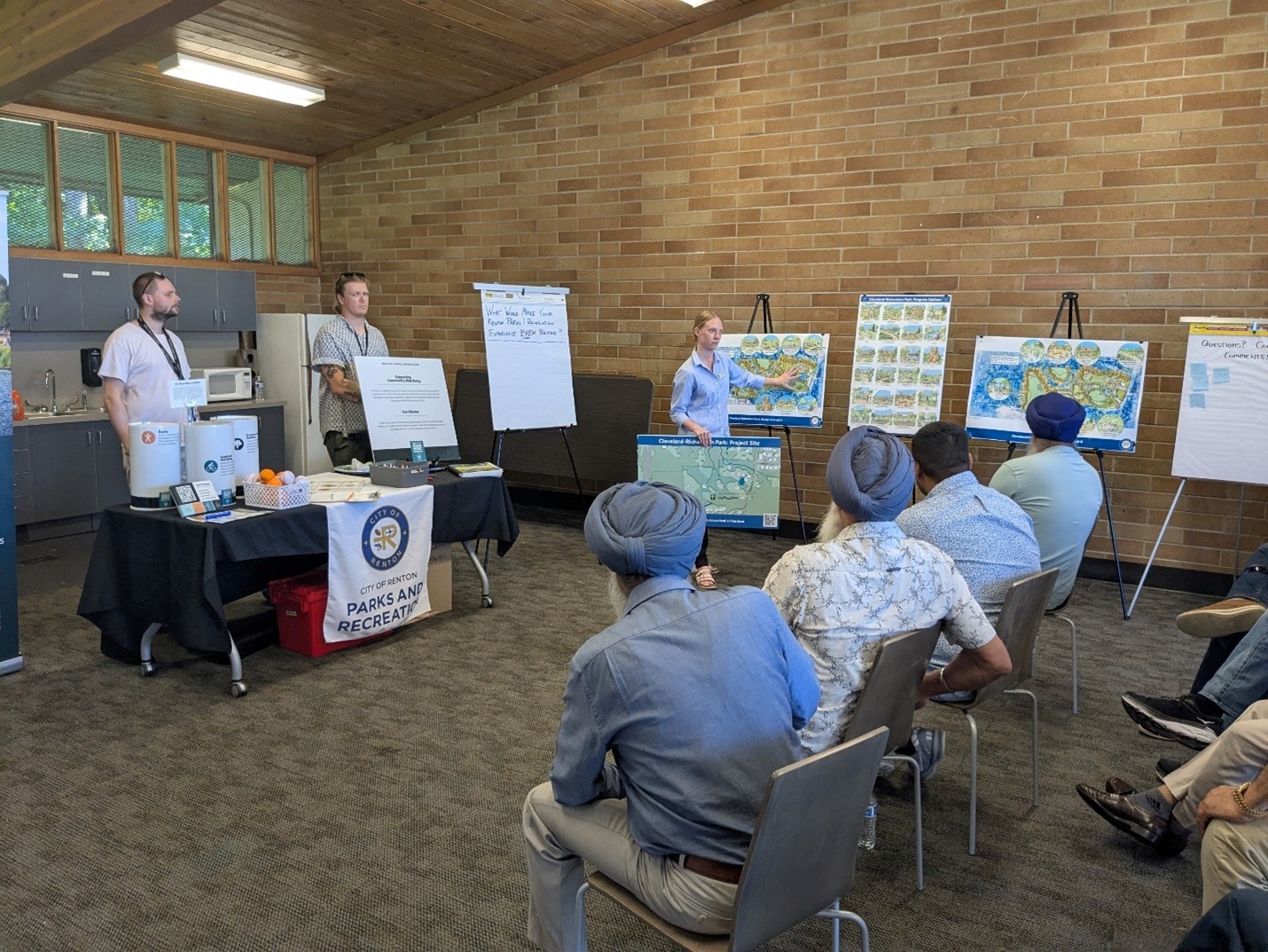 PROS-Plan-engagement-event-showing-various-community-members-seated-looking-at-various-charts-and-renderings.jpg