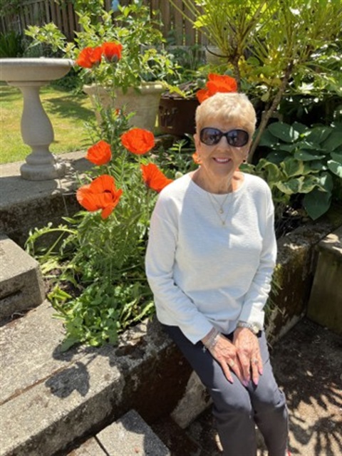 Photo-of-Toni-Nelson-sitting-by-flowers-in-a-garden.jpg