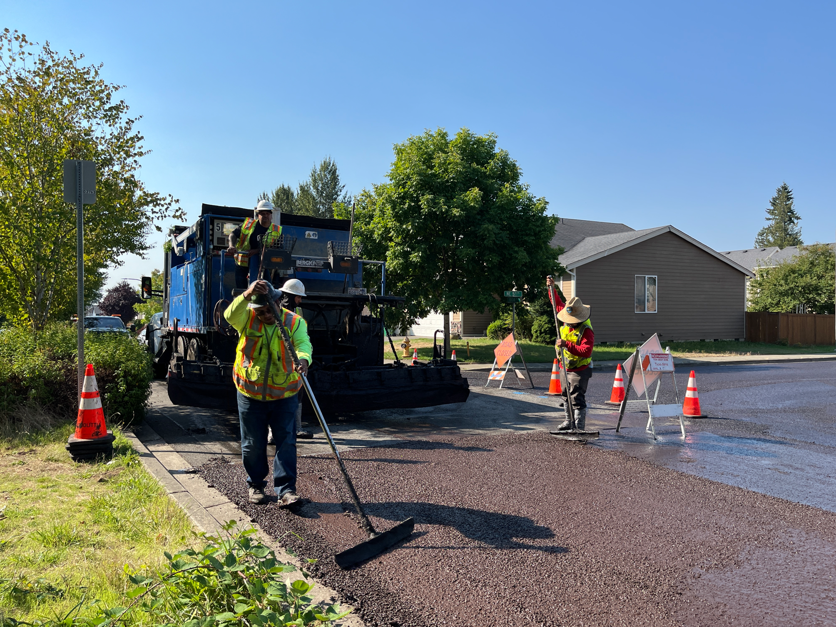 Slurry seal workers applying slurry seal to the pavement