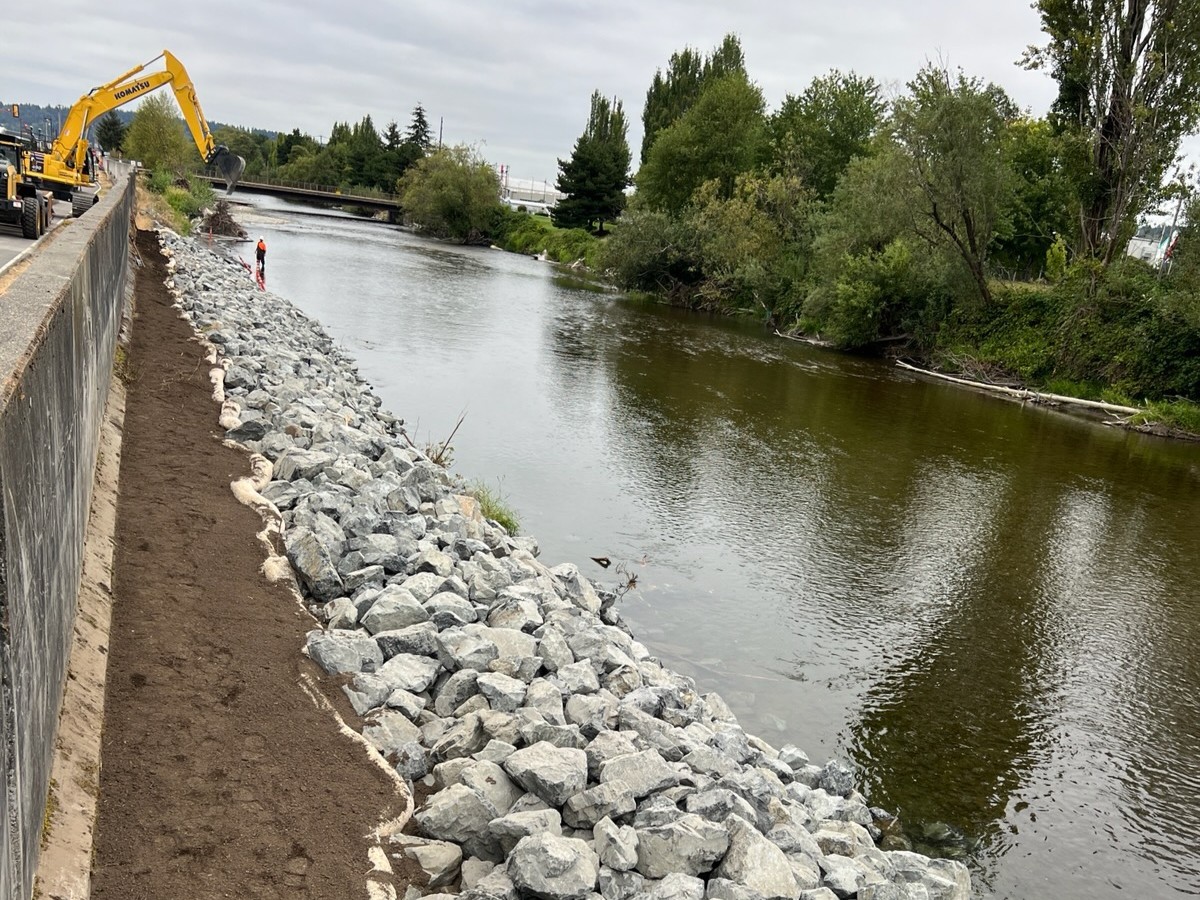 levee being actively repaired showing rocks and dirt along the Cedar River.jpeg